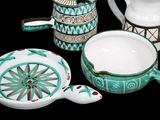 four pieces of pottery sitting on a black surface