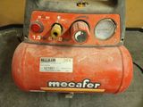 a red air compressor sitting on top of a table