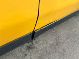 a small crack in the side of a yellow car