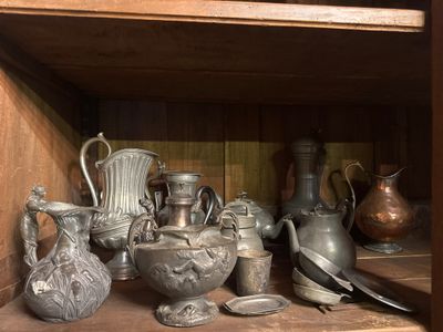 many silver vases on a shelf in a wooden cabinet