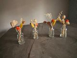 five small vases with dried flowers in them on a table