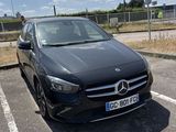 a black mercedes car parked in a parking lot