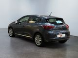 the back of a grey car in a room with a white wall