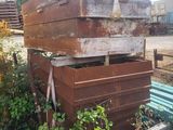 a pile of wooden crates sitting next to a blue bench