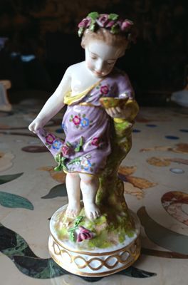 une figurine représentant une petite fille avec des fleurs dans les cheveux