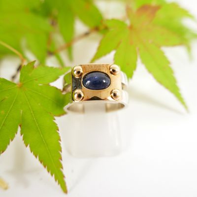 a picture of a ring with a blue stone on it