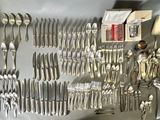 a lot of silverware on a table with a box of silverware