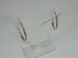pair of gold and silver hoop earrings on a clear display stand