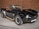 a black sports car parked in front of a brick wall