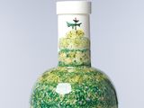 un vase vert et blanc orné d'un oiseau