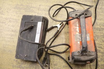 an orange and black device and a charger on the floor