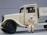 a toy man standing in front of a toy truck