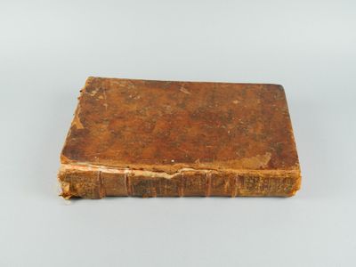 un vieux livre posé sur une surface blanche