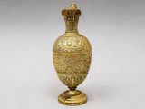 an image of a gold vase on a white surface with a white background