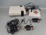 une console Nintendo et deux manettes posées sur une table