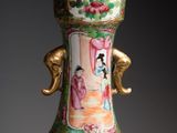 a large vase with a gold handle on a table