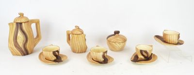 a group of wooden teapots and cups and saucers