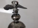 a silver statue of an eagle on top of a pole