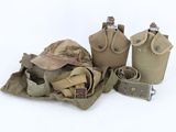 three canteens, a hat, a belt, and other items are sitting on a white surface
