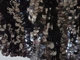 a black and silver sequinned skirt hanging on a wall