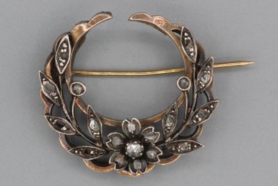 une broche en argent ornée d'une fleur et de feuilles