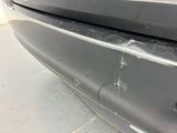 the front bumper of a car with a dent in it