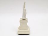 statue of a cat sitting on top of a white pedestal
