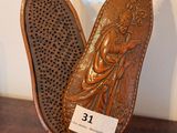 a wooden sculpture of a woman with a hairbrush in her hand