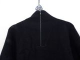 the back of a black sweater hanging on a hanger