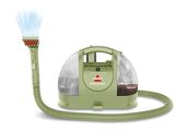a close up of a green vacuum cleaner with a hose