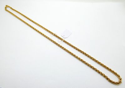 une chaîne en or avec un maillon allongé sur un fond blanc