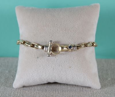 un gros plan d'un bracelet posé sur un oreiller, lui-même posé sur un autre oreiller