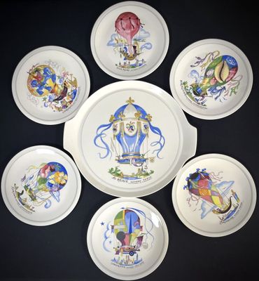 six assiettes ornées de motifs représentant des montgolfières sont disposées en cercle