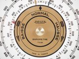 a close up of a barometer on a white surface