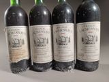 four bottles of wine are lined up on a table