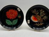deux assiettes noires ornées de fleurs rouges et jaunes