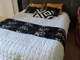 a bed that has a black and white blanket on top of it
