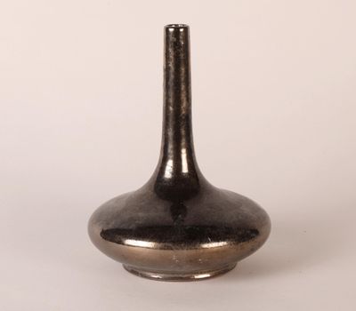 a black vase that is sitting on a white surface