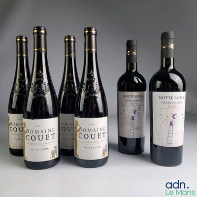 six bouteilles de vin sont alignées sur une table