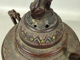 a bronze statue of a dog on top of a bowl