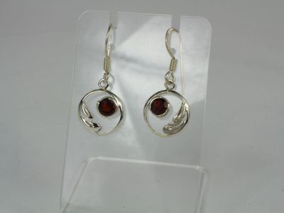a pair of silver earrings with garnets on them