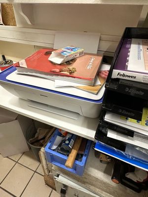 une pile de fournitures de bureau posée sur une étagère dans une salle de bains