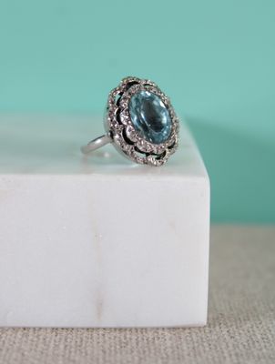 une image représentant une bague sertie d'une topaze bleue entourée de diamants blancs