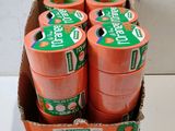 several rolls of orange tape in a box on a white surface