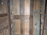 an open door to a wooden room with a white tile floor