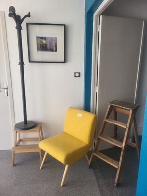 une chaise jaune et une échelle dans un coin de la pièce