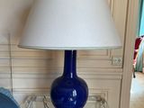 a blue lamp that is on top of a glass table