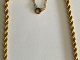 gold plated necklace with a chain that has a knot around the neck