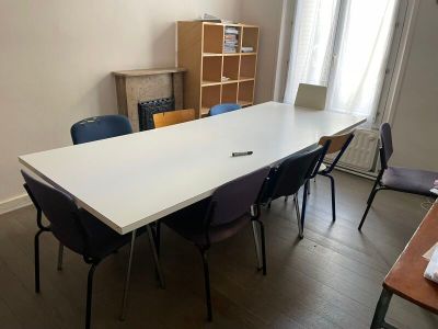 a long table with chairs and a laptop on it