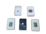 quatre sous-verres carrés en verre, ornés de motifs variés sur un fond blanc